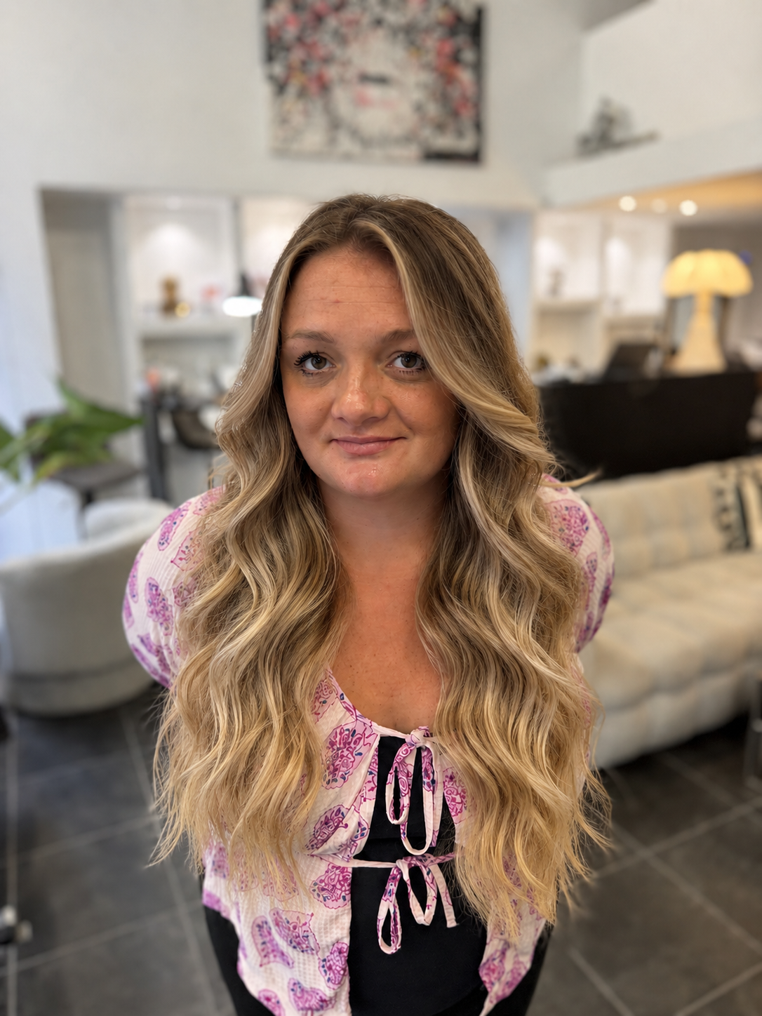 Vue de face de très longs cheveux ondulés, balayage blond doré, miel et beige clair sur base châtain clair