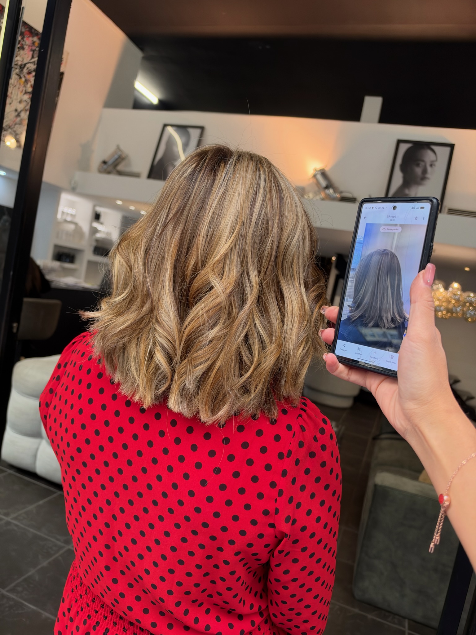 Vue de dos d'un carré mi-long ondulé aux épaules, balayage blond doré, miel et caramel sur base châtain clair