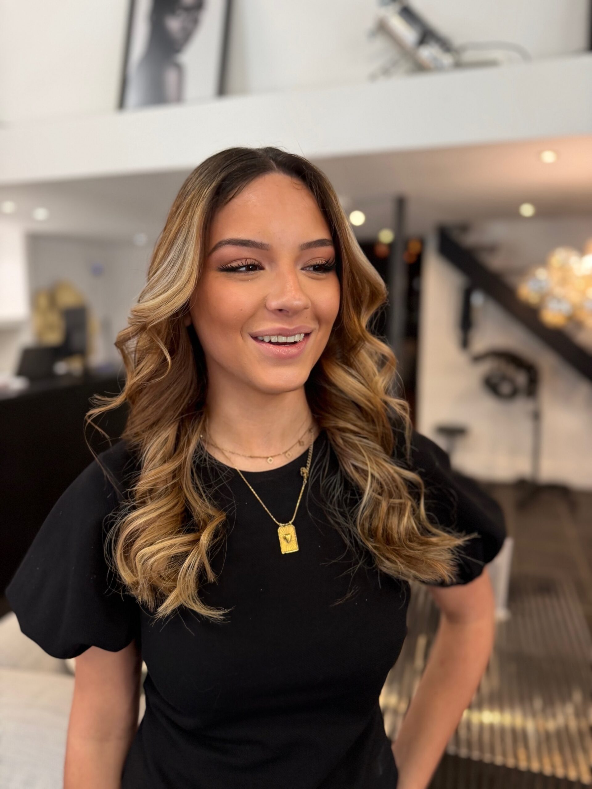 Balayage blond doré lumineux avec mèches de contouring sur cheveux mi-longs châtain clair, brushing ondulé