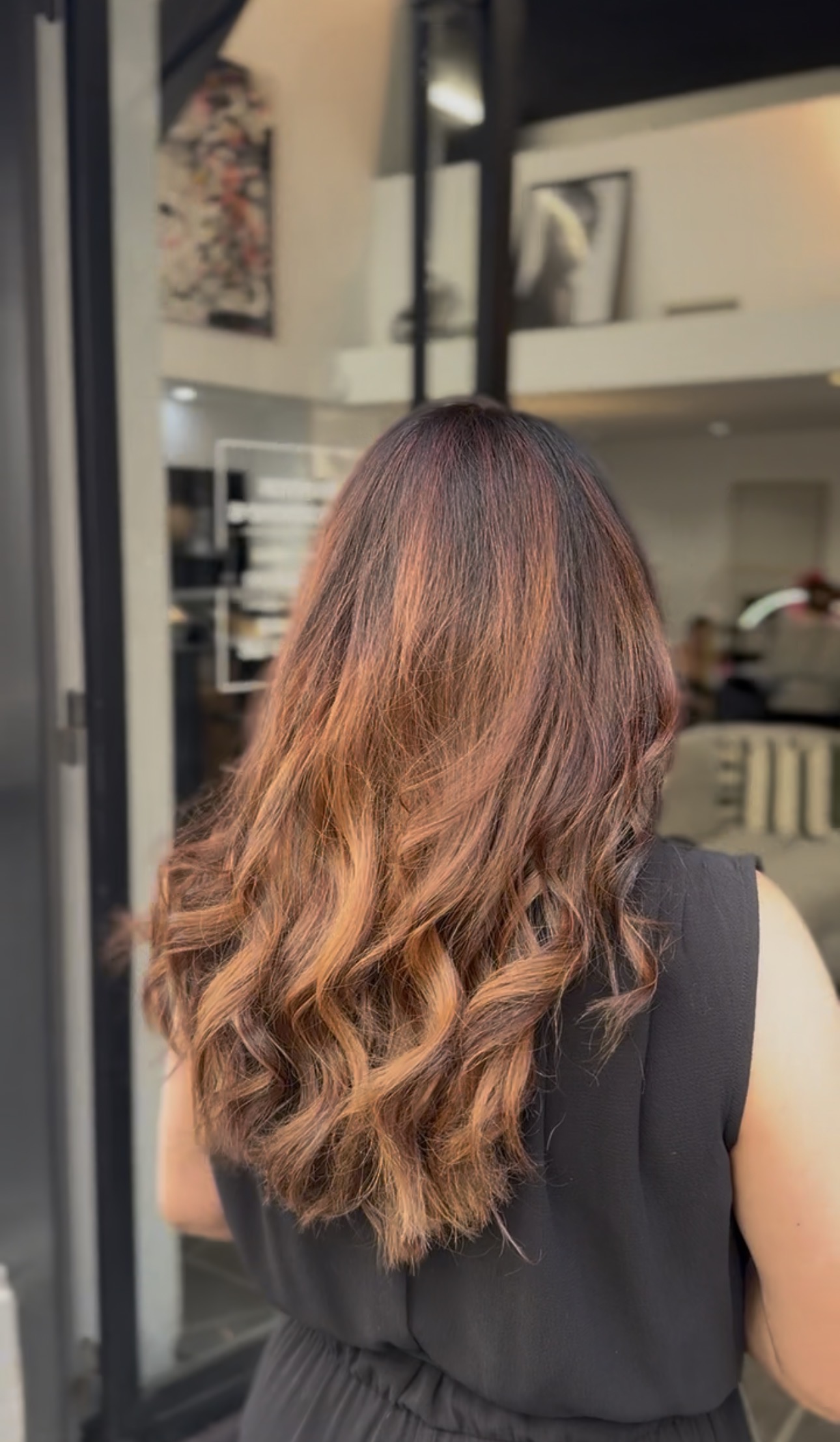 Vue de dos de cheveux longs ondulés, balayage cuivré sur racines brunes