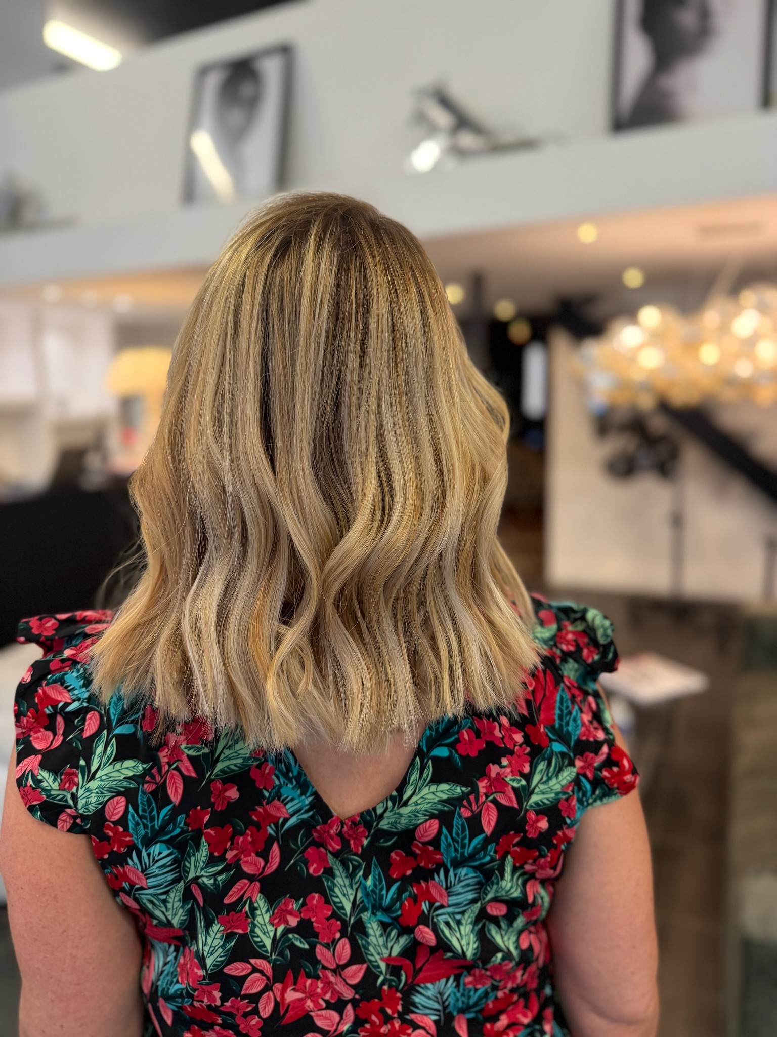 Vue de dos d'un carré long légèrement ondulé, balayage blond doré, miel et beige sur base blond foncé