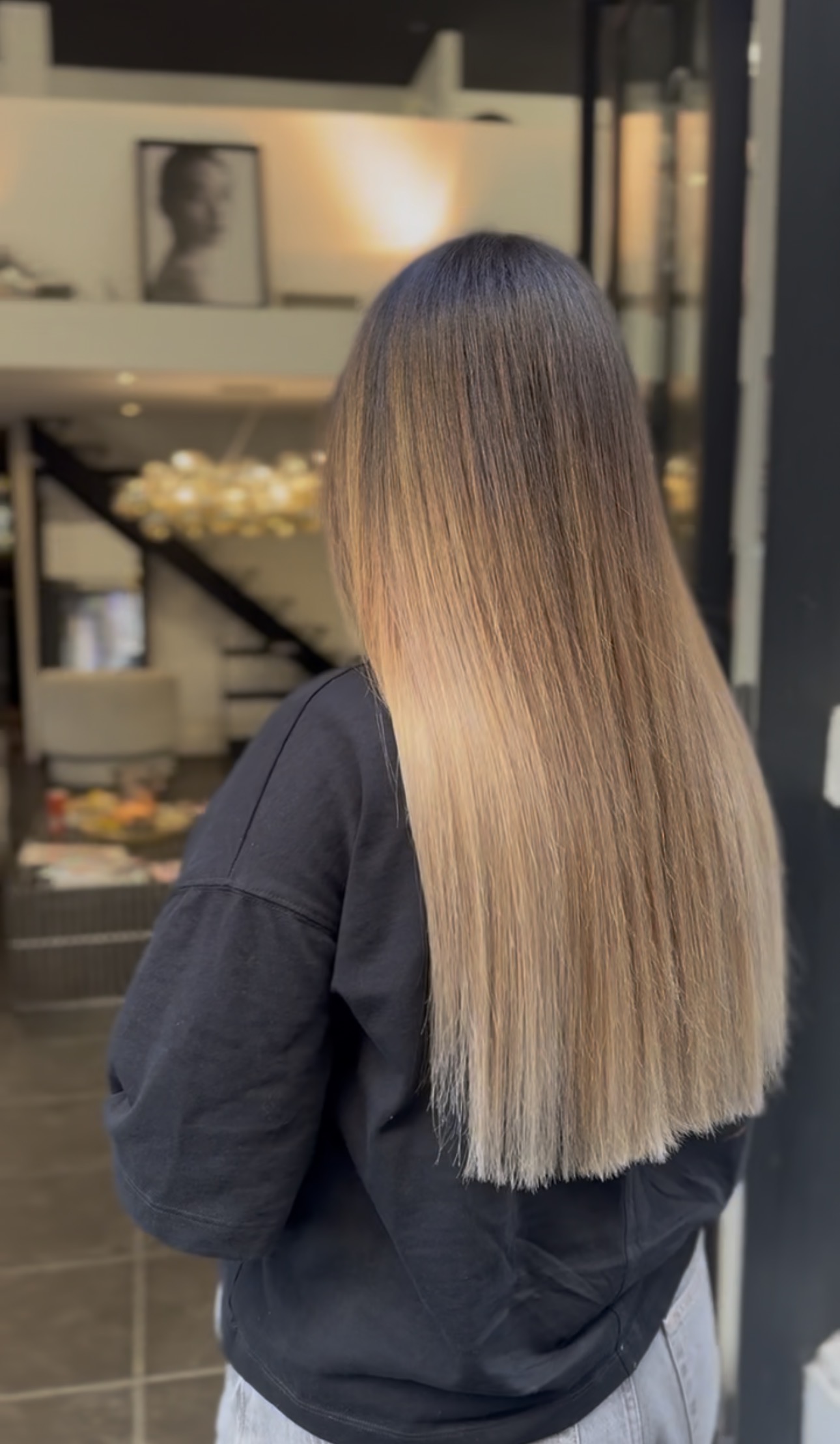 Vue de dos de cheveux longs lisses, balayage dégradé du brun naturel au caramel puis au blond champagne
