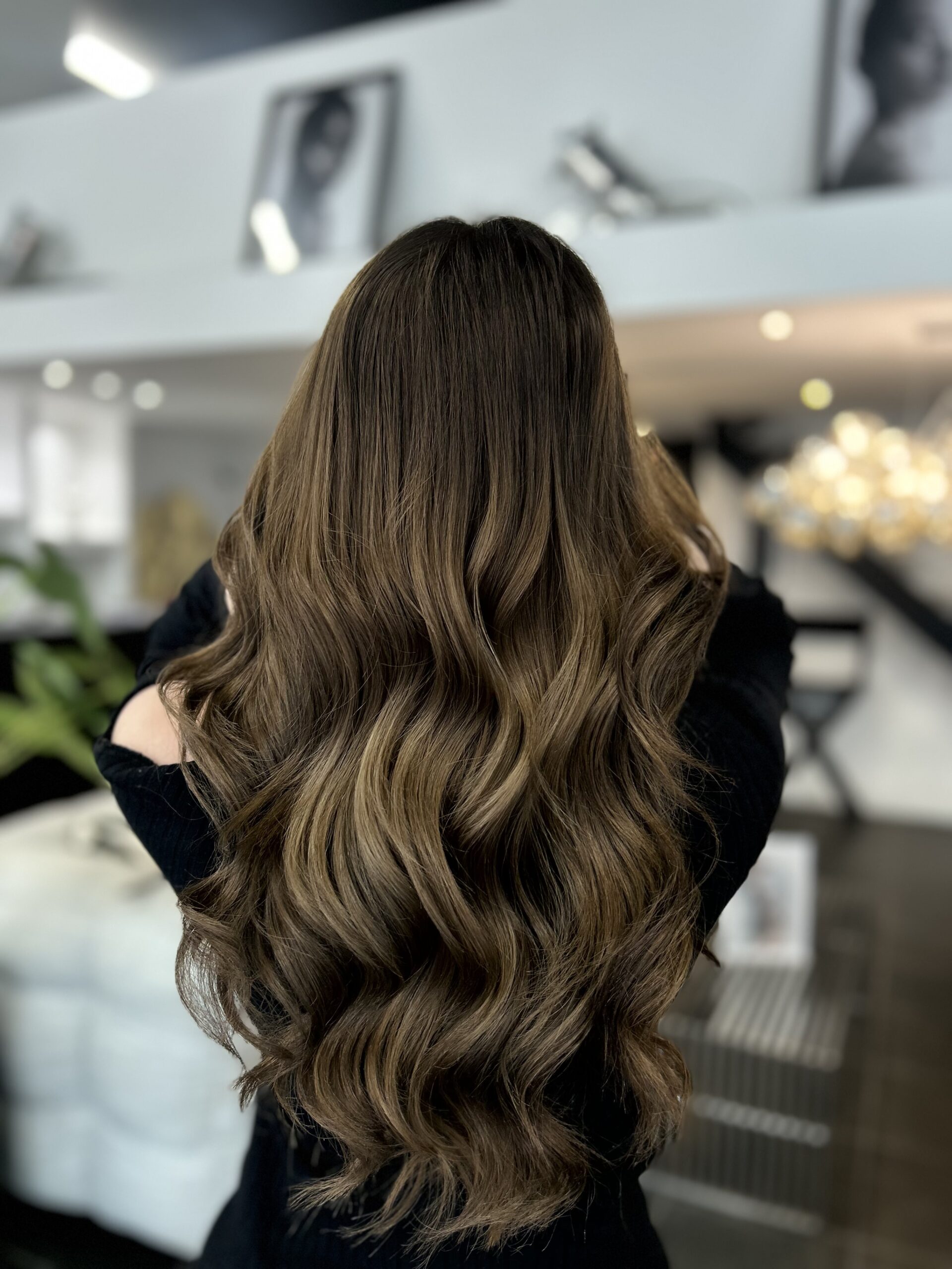 Vue de dos de cheveux très longs, coloration châtain cendré avec balayage subtil, larges ondulations