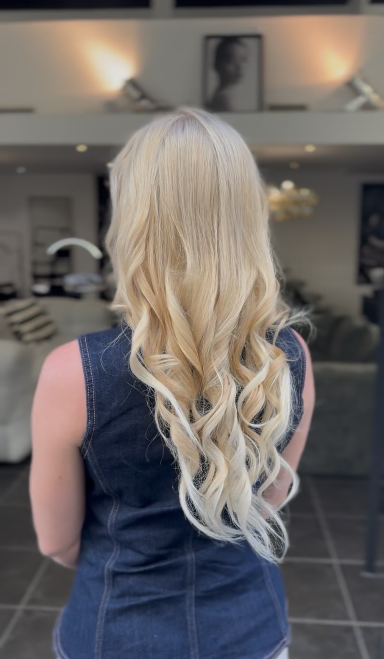 Cheveux longs blond doré lisses sur le haut avec de larges ondulations vers les pointes, vue de dos