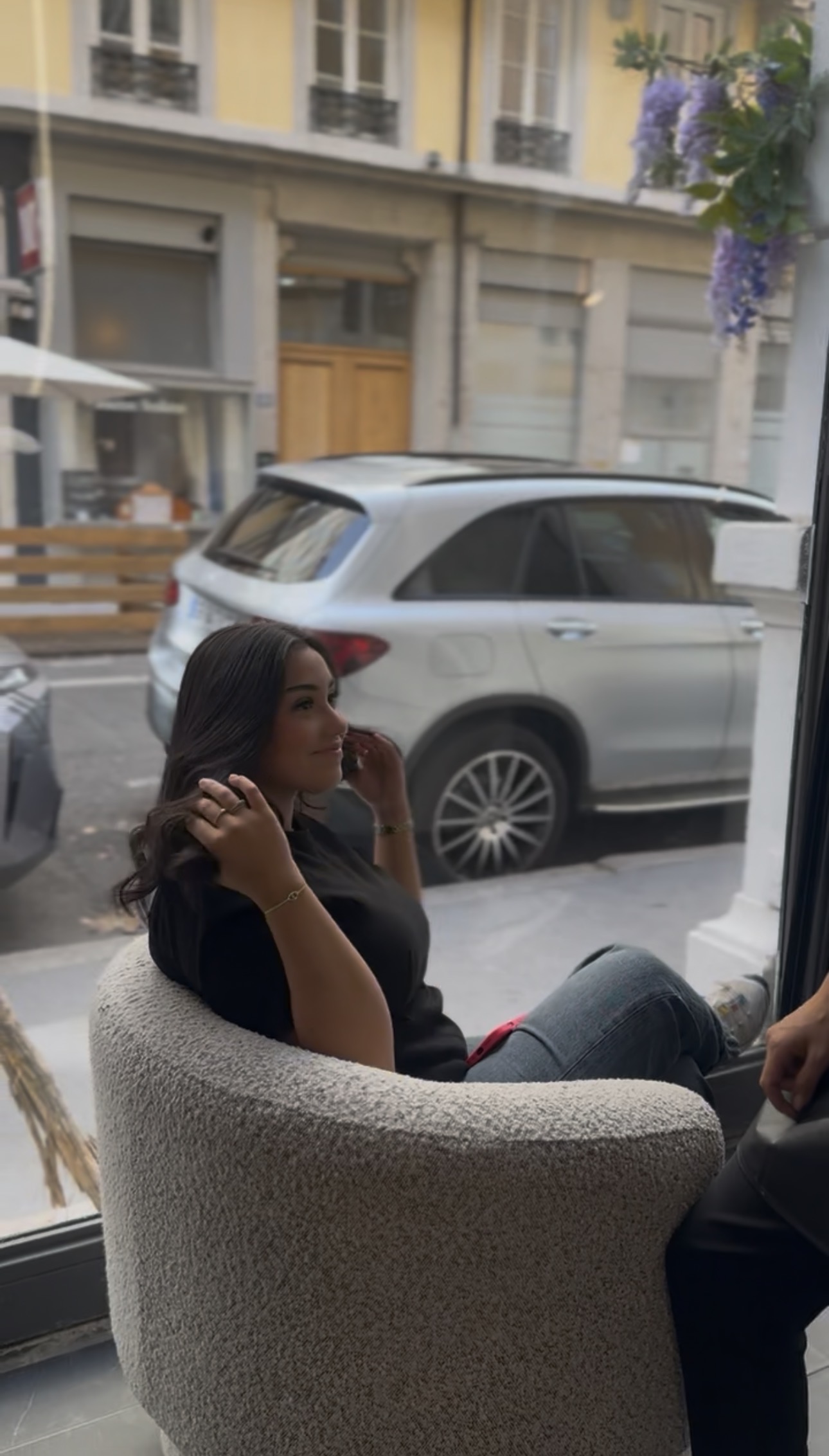Cheveux mi-longs brun foncé en brushing souple et ondulé, raie au milieu, vus de trois-quarts