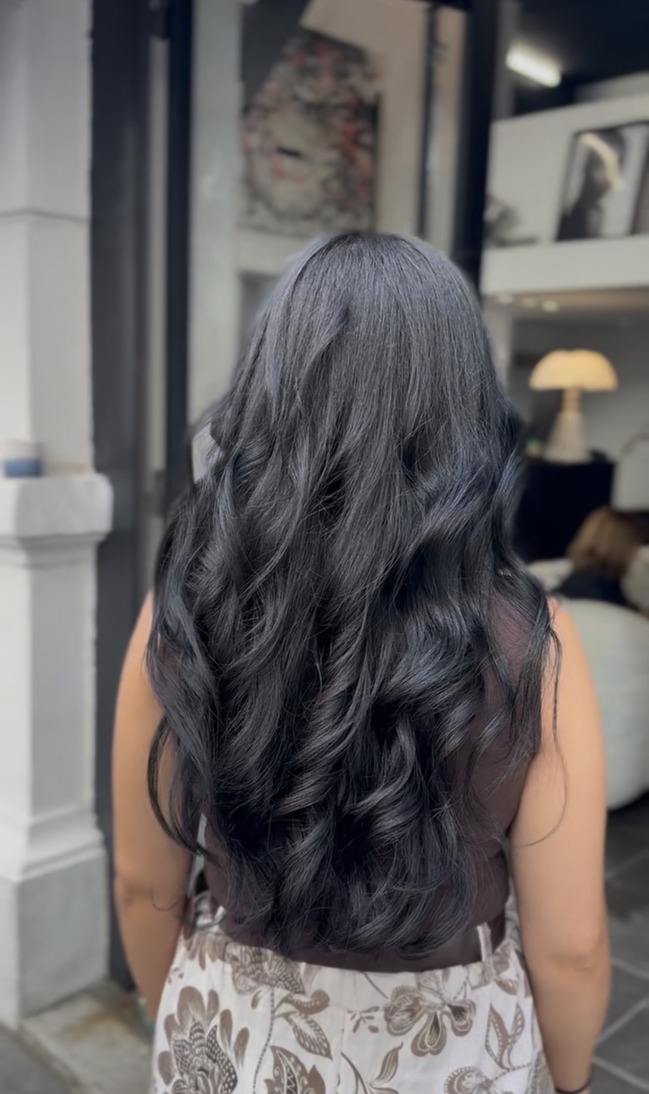 Longs cheveux dégradés noir corbeau, en larges ondulations souples, vue de dos