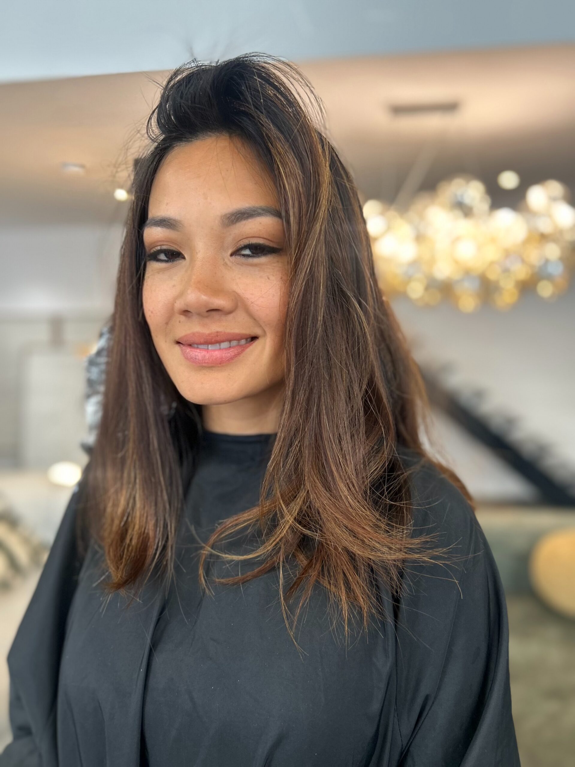 Coupe mi-longue dégradée aux reflets balayage châtain et caramel, vue de face