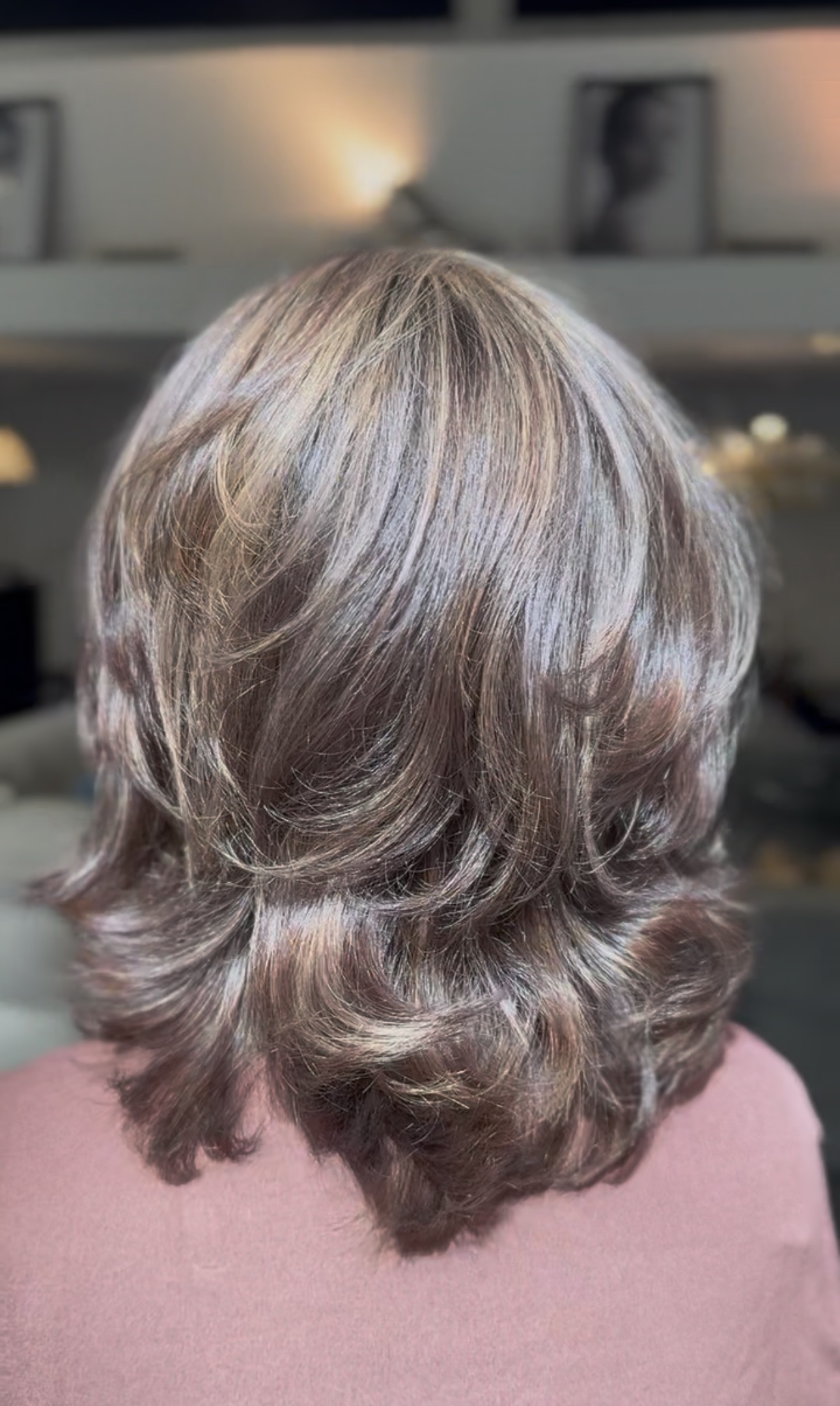 Coupe mi-longue dégradée et volumineuse aux pointes ondulées, châtain clair méché, vue de dos