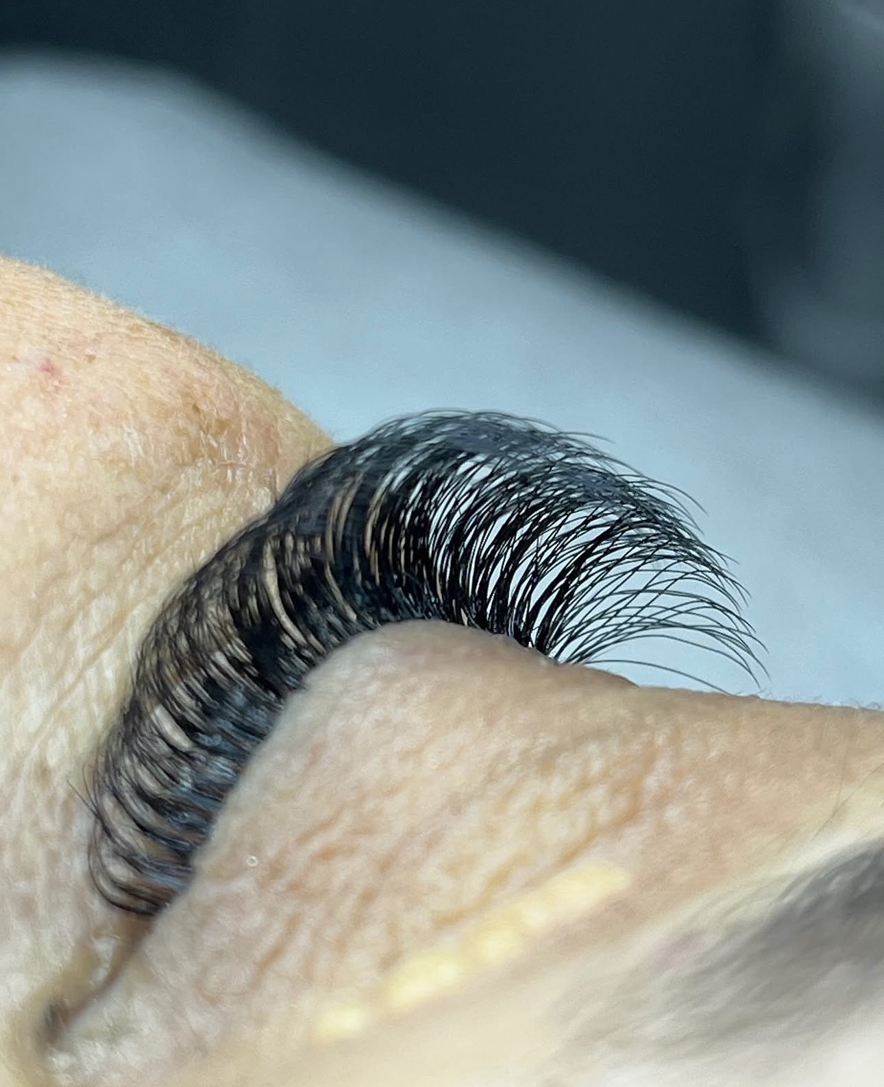 Gros plan sur un œil fermé, extensions de cils denses et courbées en volume russe
