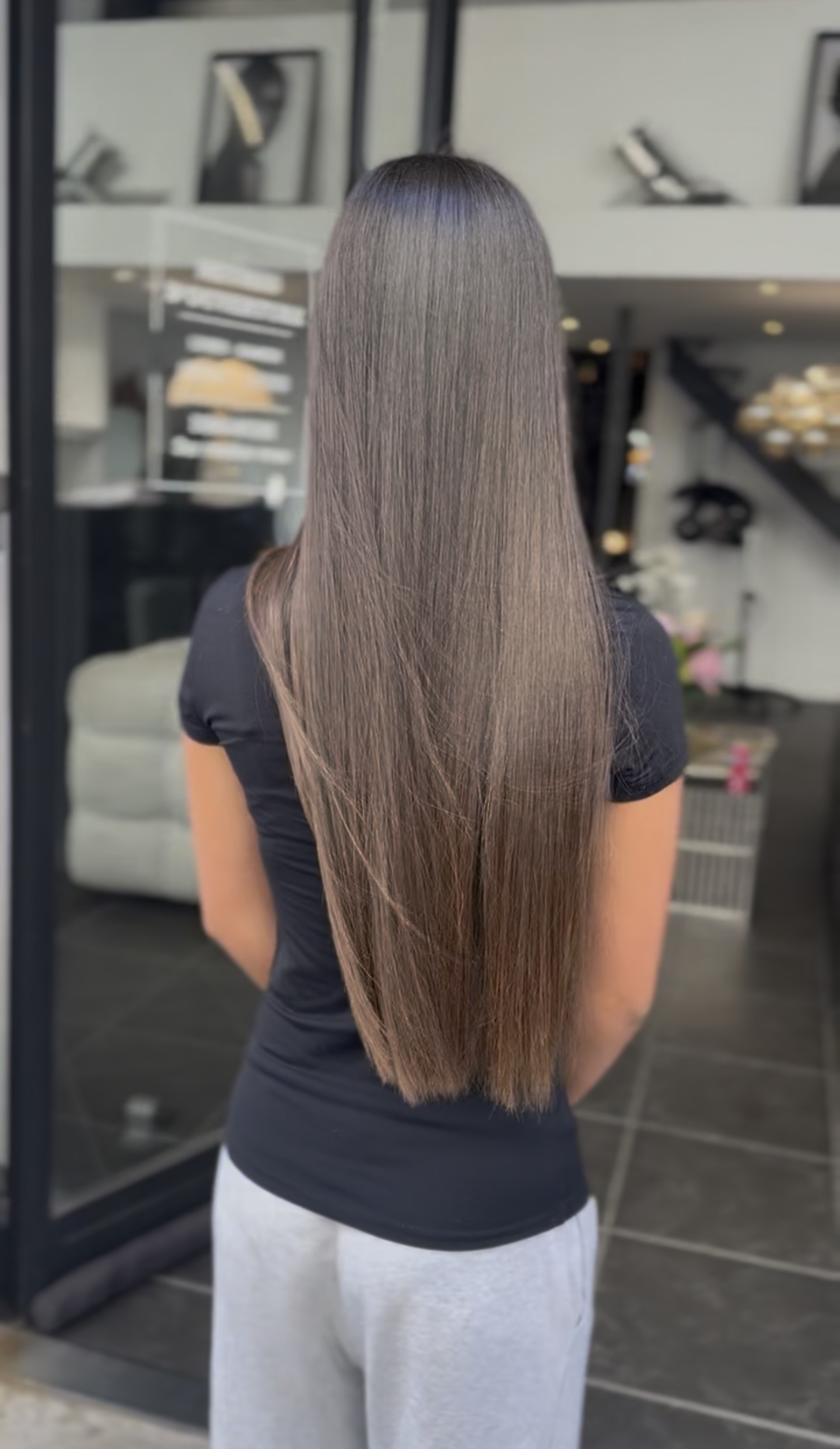 Cheveux longs parfaitement lissés vus de dos, résultat d'un lissage au salon