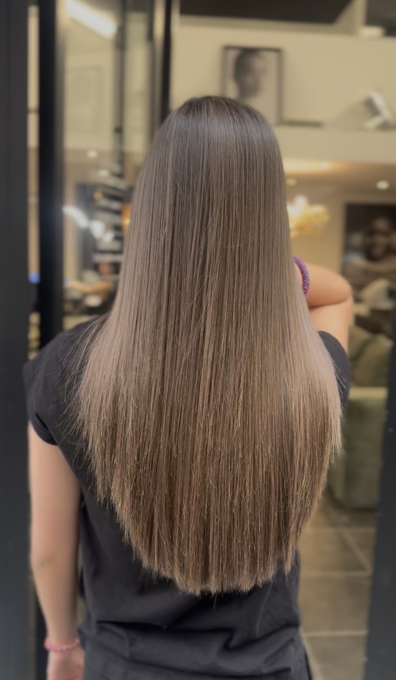 Cheveux lisses et soyeux vus de dos, résultat d'un lissage au salon