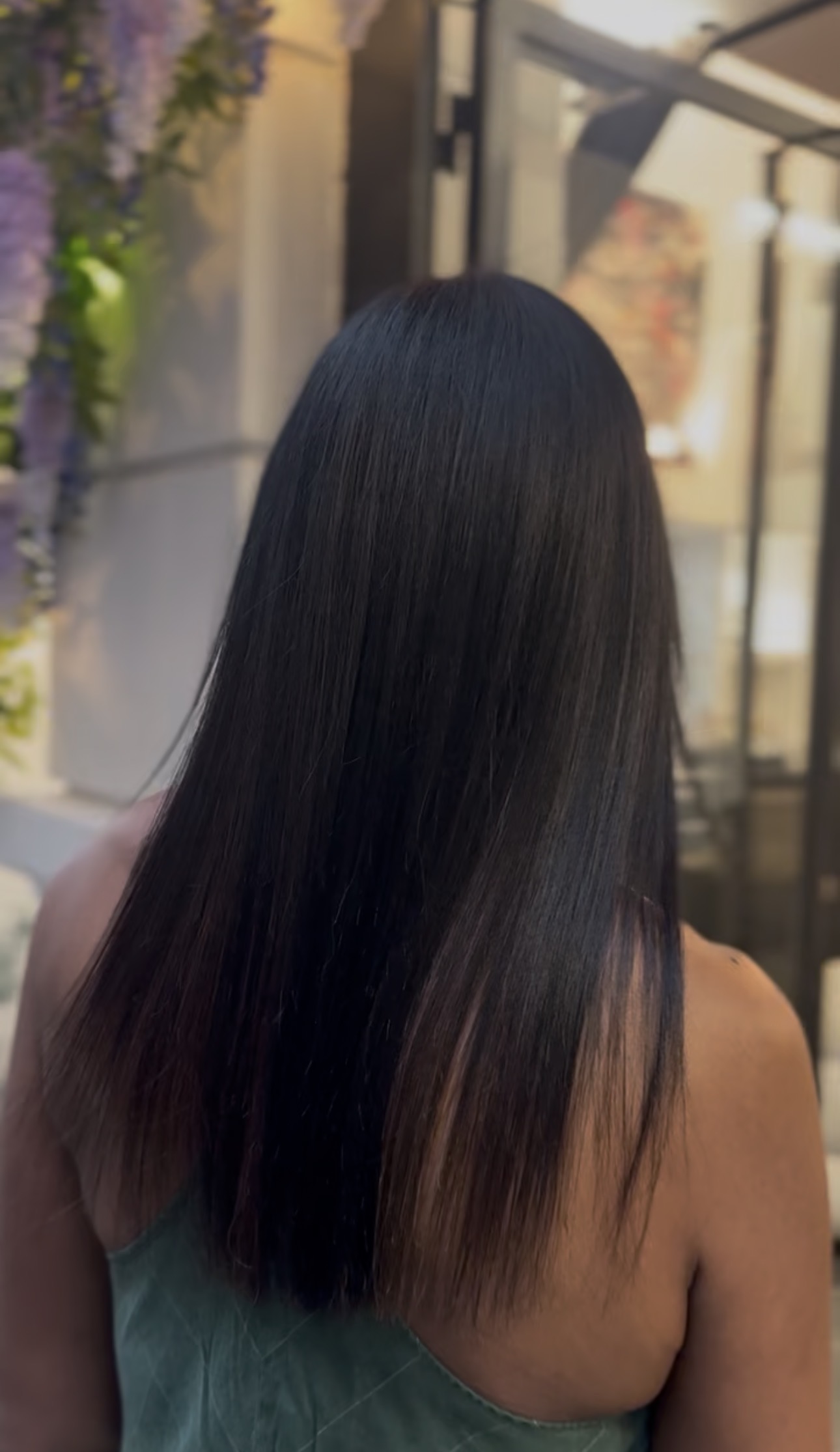 Cheveux longs lissés vus de dos, résultat d'un lissage au salon