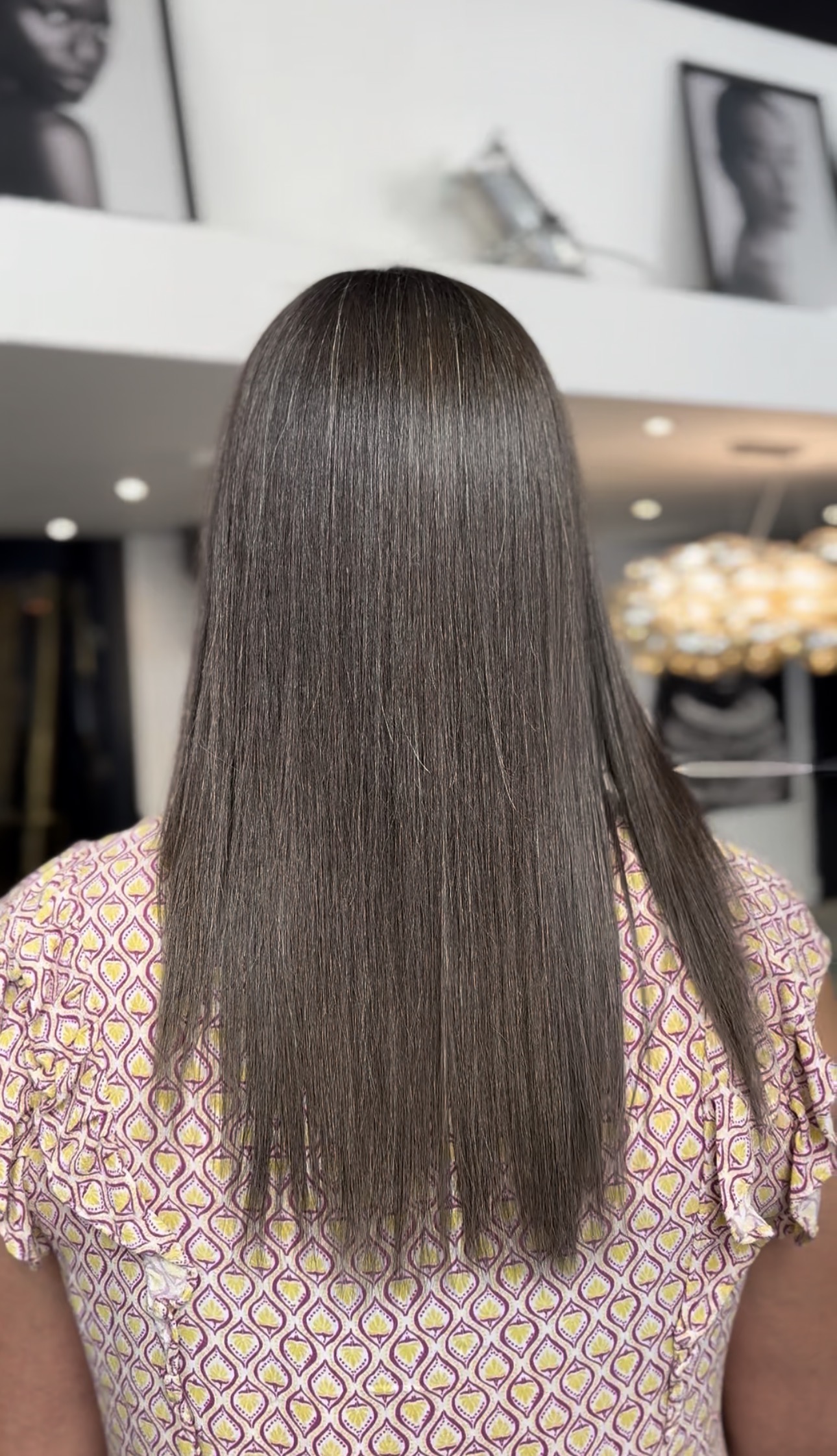 Cheveux longs lissés vus de dos, résultat d'un lissage au salon