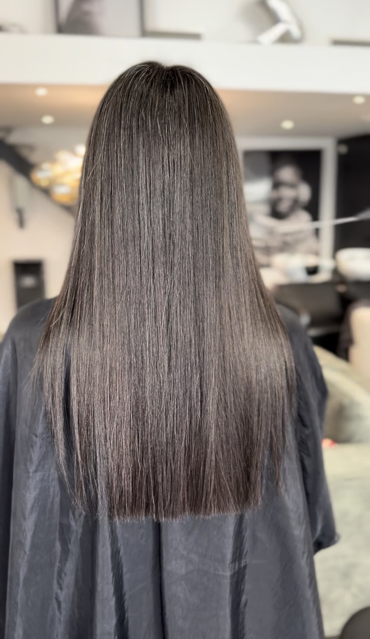 Cheveux lisses et soyeux vus de dos, résultat d'un lissage au salon
