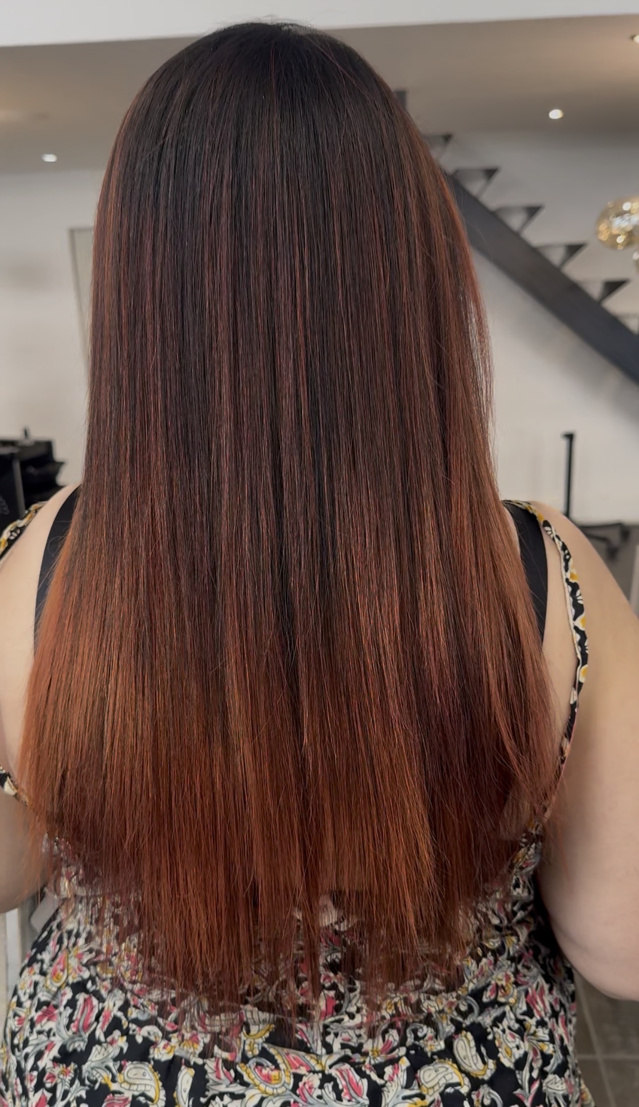 Cheveux longs lisses et soyeux vus de dos, résultat d'un lissage au salon