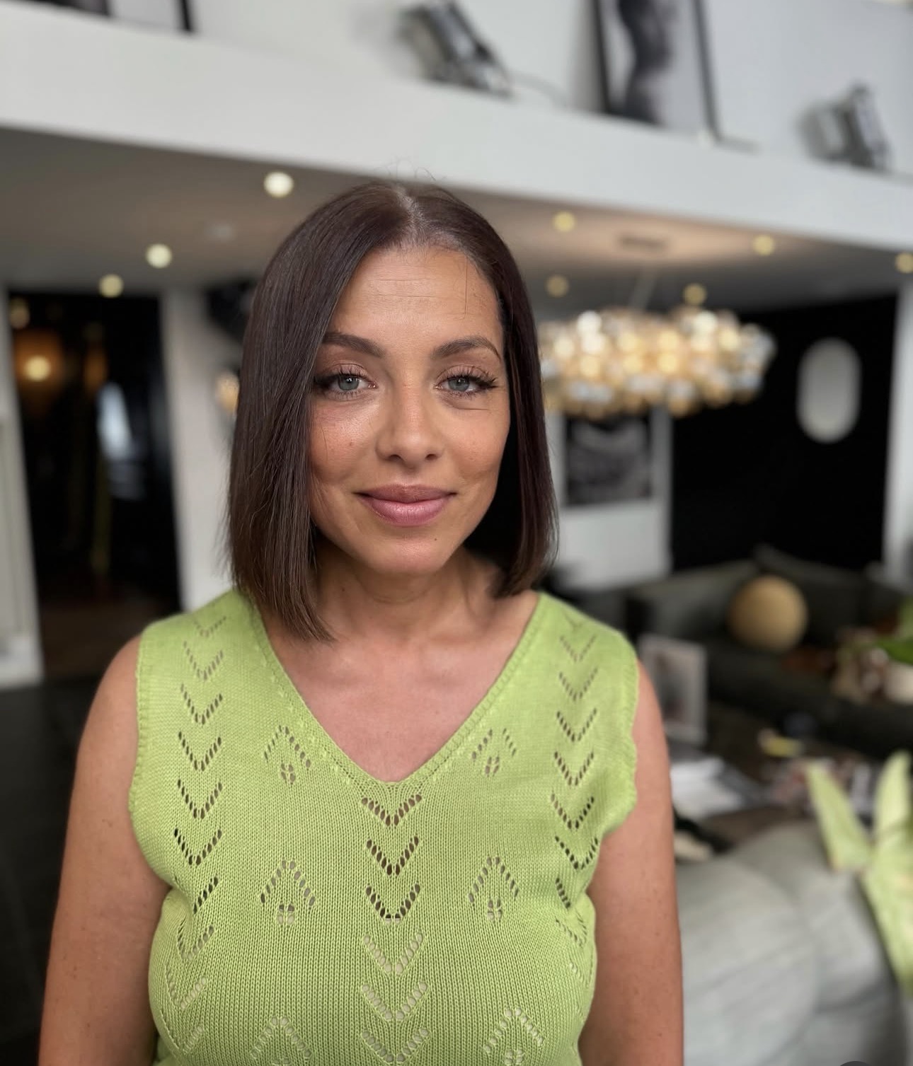 Portrait de face d'une femme souriante avec un carré droit lisse et soigné, brun foncé