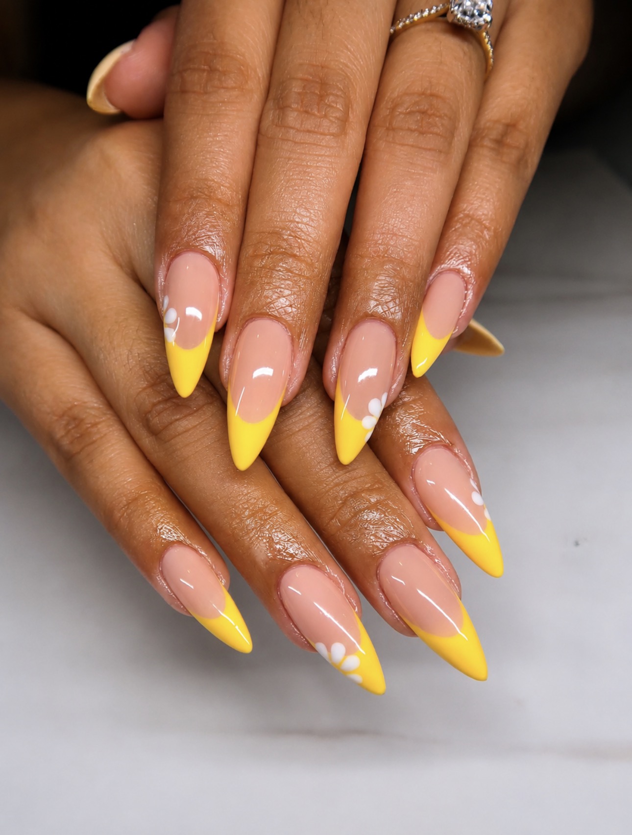 Ongles amande base nude, French jaune vif et petites marguerites blanches